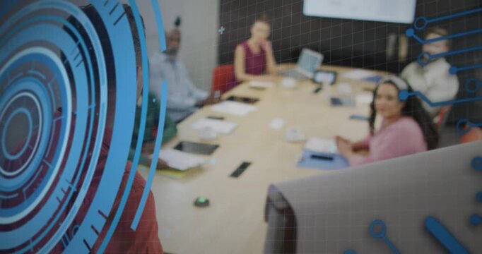 Presenter in red shirt turning to colleagues gesturing while code overlay updating in tech meeting