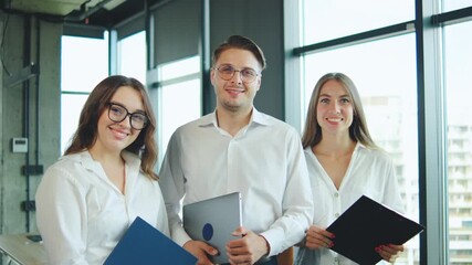 Team members pose confidently in modern office setting, showcasing collaboration and professionalism during a project meeting