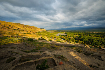 Scenic sunset views looking across the Kura River from the top of the ancient rock town of Uplistsikhe near the city of Gori, Georgia © hyserb