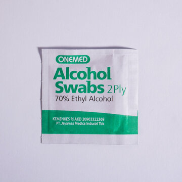 Jakarta, Indonesia - August 26th, 2025 - Onemed brand alcohol swabs 2 ply ethyl alcohol isolated on square white background from top angle view.