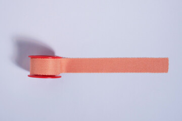 Medical tool equipment plaster tape roll isolated on horizontal white background from top angle view.