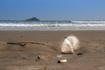 Plastic cup thrown like garbage on the sand of the  beach in Brazil