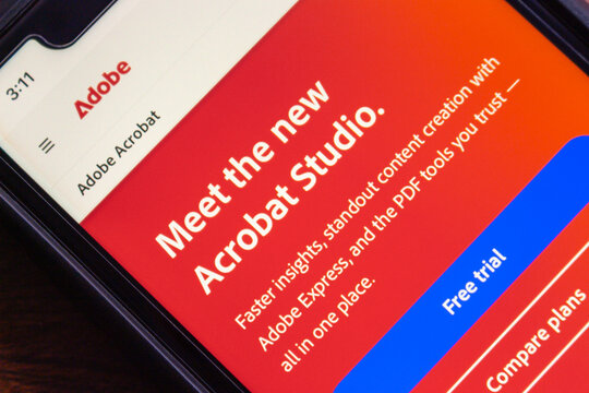 Mexico City, MEXICO - Aug 26 2025 : Close-up of smartphone screen showing Adobe Acrobat Studio website, featuring PDF tools, Adobe Express, and a free trial option.