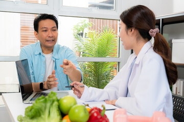 Asian nutritionist consulting patient in clinic, meal plan discussion, healthcare advice, weight loss support, doctor talking and explaining patient for nutrition consultation, wellness care.