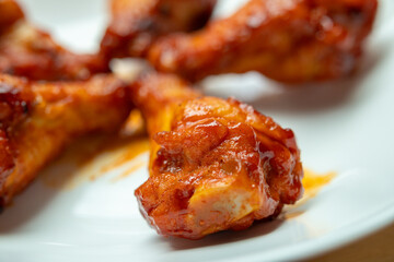 Grilled spicy chicken wing on white plate