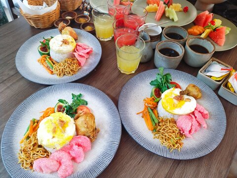 The hotel breakfast menu includes special fried rice with eggs, fried noodles, and crackers. There is also bread, juice, coffee, and fresh fruit slices