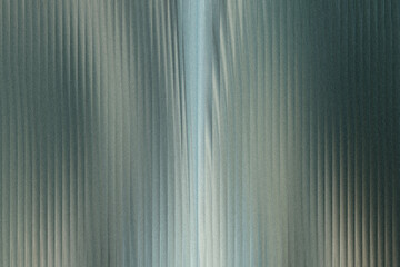 Obraz premium A closeup view of a corrugated metal surface with vertical lines and a subtle blueish sheen, creating a textured industrial background