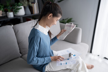 Asian woman holding paper document calculating money savings paying bills in mobile application using smart phone payment online with paying household bills tax insurance managing budget