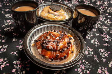 Two assorted cinnamon rolls with two cups of hot coffee or tea