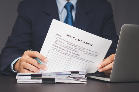 Close-up of legal paperwork in hands of professional man signing agreement.