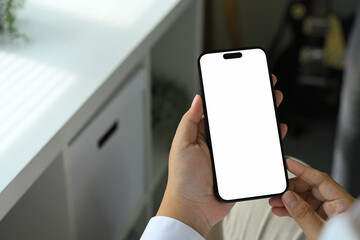 Close up of person holding smartphone with blank white screen mockup for mobile app design