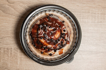Top view of a chocolate chip cinnamon bun in a takeaway container