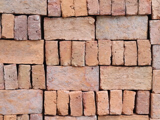 stacked red clay bricks for building material