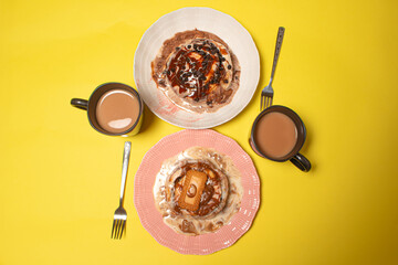 Two cinnamon rolls with coffee for a breakfast or dessert date