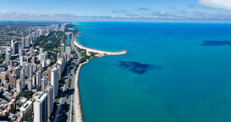 Aerial View of Chicago Skyline and Lake Michigan Shoreline on a Clear Day” Drone aerial photo of the Chicago skyline along Lake Michigan with high-rise buildings, Lakeshore Drive, and sandy beaches