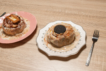 Two different fresh cinnamon buns served on a wooden table