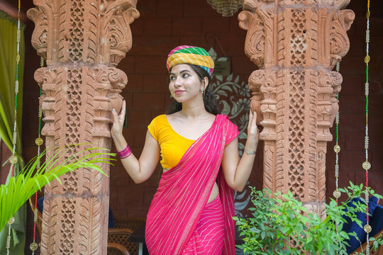 Young indian woman wearing pink saree and colorful turban standing outdoor. Culture of india. Rajasthan people