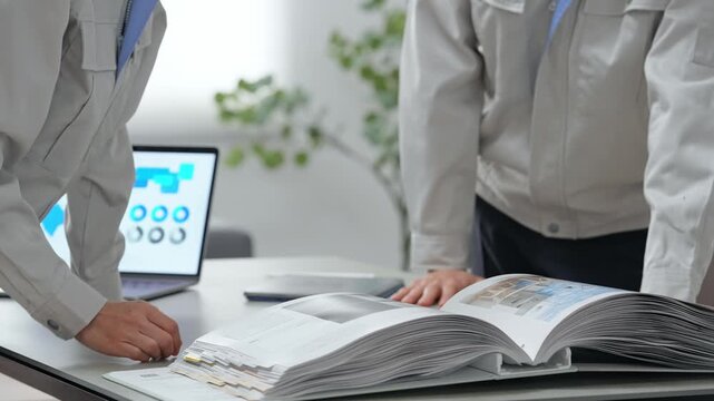 A group of workers having a meeting while looking at a catalog