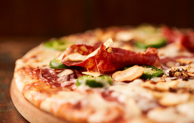 Pizza with salami, mozzarella cheese and jalapeno pepper. Wooden background. Soft focus.
