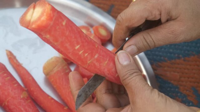 Closeup of hands cutting fresh orange carrots