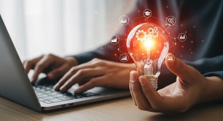 Person holding glowing light bulb with digital network and gears