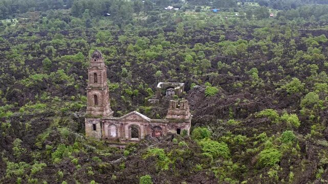 DRONE: ORBIT AND ZOOM OUT OF THE RUINS AT SAN JUAN PARANGARICUTIRO NEAR PARICUTIN VOLCANO