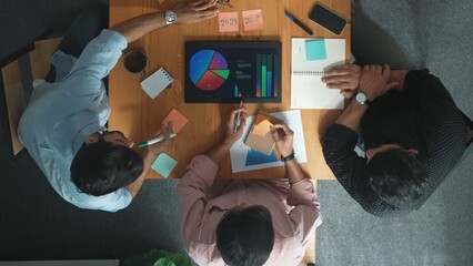 Top aerial view of diverse team writing colorful sticky notes to brainstorm marketing idea. Multicultural business people taking a note about plan while leader standing and walking away. Convocation.