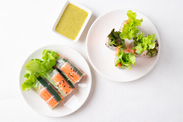 Salad roll with crab stick, carrot, cucumber and lettuce wrapped with rice paper eating with dipping sauce, Top view