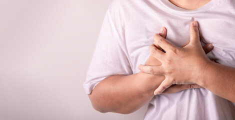 heart disease concept. woman pressing on chest with painful expression. severe heartache and having heart attack or painful cramps.