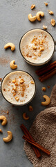 Cozy autumn beverage with creamy froth, sprinkled cashews, and warm cinnamon sticks evokes comfort and seasonal indulgence.