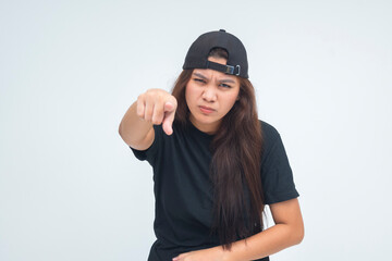Angry young boyish woman pointing straight ahead with a stern, confrontational expression. Isolated on a white background.