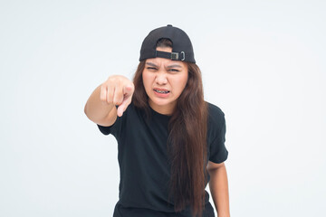 Angry young boyish woman leaning forward and pointing directly ahead with a fierce, accusing look....