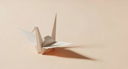 Elegant origami paper crane casting a gentle shadow on a soft peach background, symbolizing peace and hope