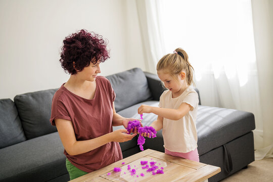 Girls kids holding playing with purple slime putty at home