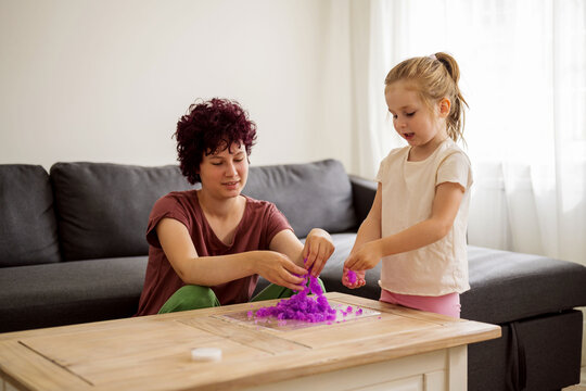Girls kids holding playing with purple slime putty at home