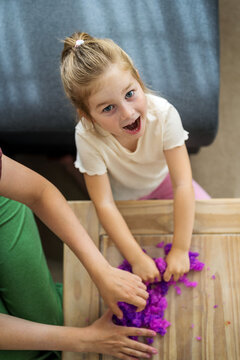 Girls kids holding playing with purple slime putty at home