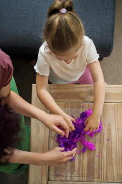 Girls kids holding playing with purple slime putty at home