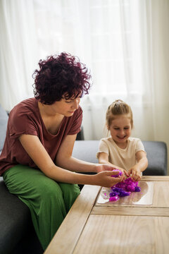 Girls kids holding playing with purple slime putty at home