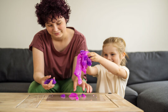 Girls kids holding playing with purple slime putty at home