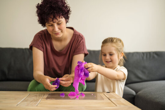 Girls kids holding playing with purple slime putty at home