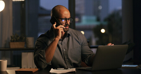 Phone call, confused and man with laptop, office and review of tax issue on website, talk and night. Financial advisor, discussion or person with mobile for communication, frustrated and working late