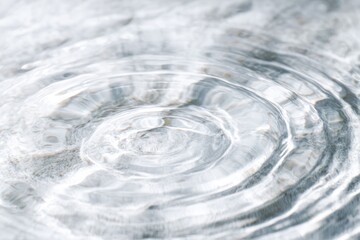 Ripples expand on the water's surface, creating concentric circles with a subtle, shimmering effect