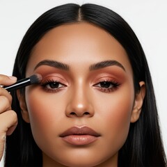 Close-up of woman applying rose gold eyeshadow with makeup brush