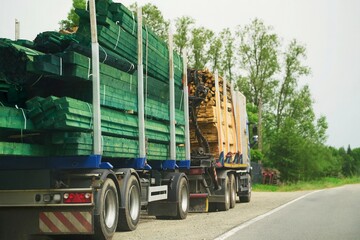 Rural road scene with trucks hauling lumber