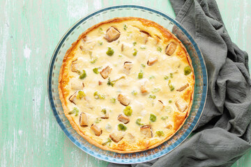 Quiche pie with fish and broccoli in a glass baking dish. Top view
