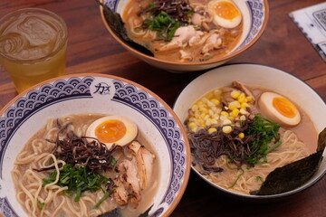 three ramen noodle soup. Tonkotsu ramen, Japanese noodle soup with soft boiled egg, scallion, sweet corn, nori, cha shu. Kirin shoyu ramen special.