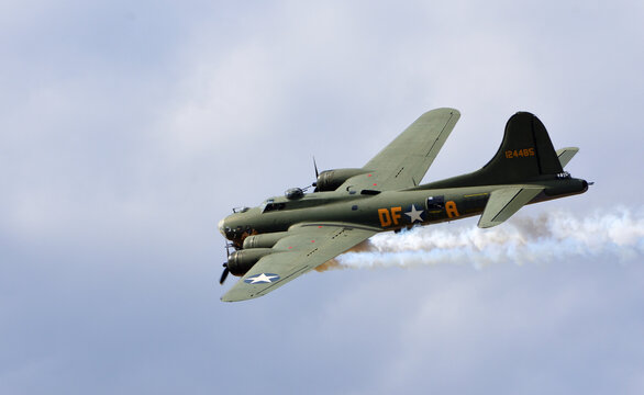 Vintage  Boeing B-17G Flying Fortress bomber aircraft known as "Sally B" in flight with smoke