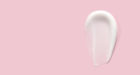 sample smear of creamy white texture on light pink background, moisturizing and skin care concept