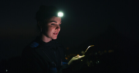 Headlamp, hiking and phone with woman in dark to search for directions to destination or location....