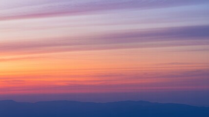 Obraz premium Abstract sky with soft, horizontal bands of color transitioning from warm orange and pink to cool purple and blue, creating a gradient effect